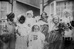 Fancy Dress competition entrants. Left to right: Henry (Harry), Win, Dot, Gladys (in front), and Alice Taylor, Gertrude and Vic (Victor) Cox.  Costumes often made of crepe paper by Emily Taylor, mother and aunt of the children.  Costumes were found many decades after her death, but sadly too fragile to keep. Date around 1920